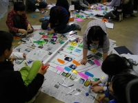 模造紙を広げてグループごとに児童たちが地域安全マップ作りをしてる写真