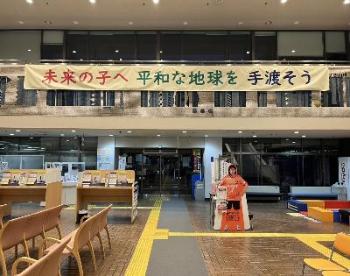 「未来の子へ平和な地球を手渡そう」と書かれた横断幕が掲示してあるロビーの写真