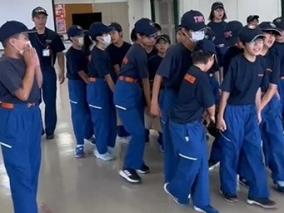 毛布担架で訓練人形を搬送する少年消防団員たち