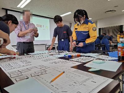 避難所運営ゲームをする少年消防団員