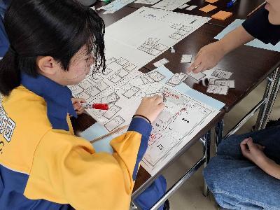 避難所運営ゲームをする少年消防団員