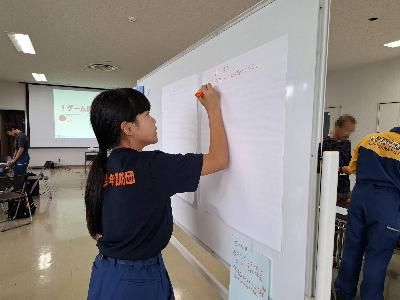 避難所運営ゲームをする少年消防団員
