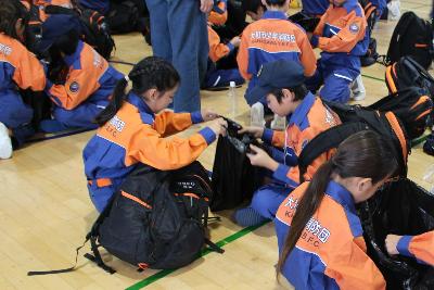 携帯トイレの使用方法を学ぶ少年消防団員