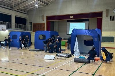 避難所で就寝スペースを設営する少年消防団員