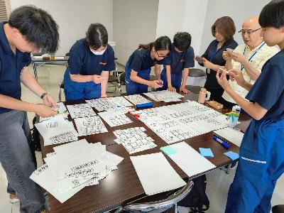 避難所運営ゲームをする少年消防団員