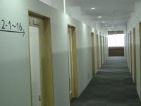 壁に書かれた、部室2-1～16の文字とその下に矢印、廊下の両側にある部室の写真