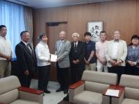 大和市全国県人会連合会会長、大阪府人会会長などを含め計8名が、大木市長に義援金を手渡ししている写真
