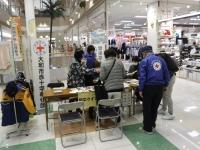 商業施設内の一角に大和市赤十字奉仕団と書かれた看板の手前で、スタッフがお客様に話しをしている写真