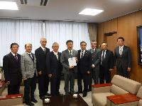 市長に目録を手渡す連合会会長と県人会メンバーの様子