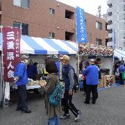 のぼり旗を立てた出店が並んでおり、お客さんがお店の前に並んで賑わっている様子の写真