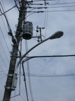 電信柱に設置されている街路灯（道路照明灯）の写真