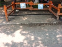 オレンジ色の木の柵がしてある自転車置き場の写真