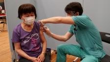 歯科医師が患者さんにコロナワクチン接種する写真