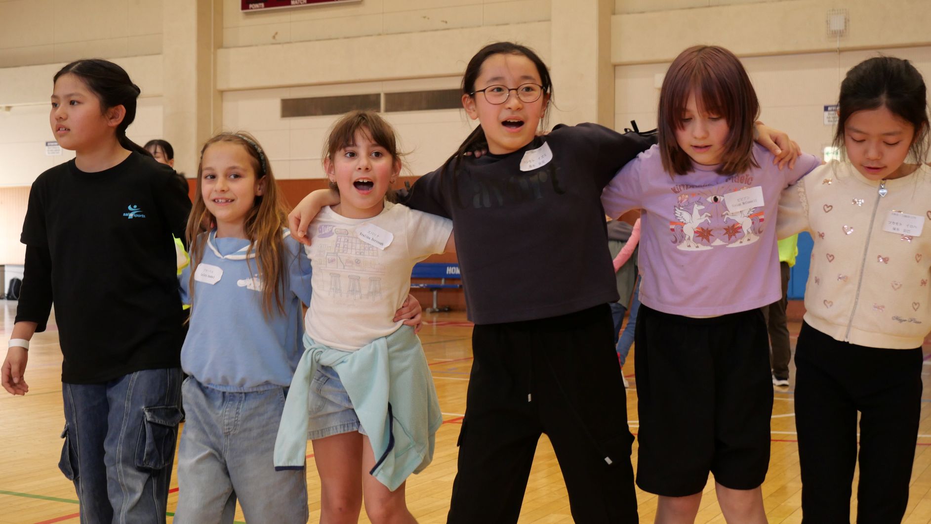 米軍の子どもたちと市内の小学生が肩を組んで二人三脚を楽しんでいる様子