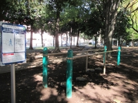 木々の植えられた公園に手すりが二つ並んでおり、手すりの間に高低差のある踏み台があるステップバランスの写真