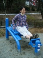 女性がカーフベンチに座り、足を伸ばした状態で前方にある板に両足をかけている写真