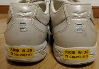 登録番号と大和市役所の電話番号がプリントされた黄色の反射ステッカーが靴のかかとに貼ってある写真