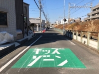 緑色で囲まれた範囲に「キッズ・ゾーン」と白文字で書かれている「キッズ・ゾーン」の道路の写真