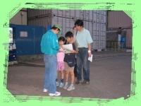 4名の親子が緑色のキャップを被ったスタッフと向き合って話しをしている写真