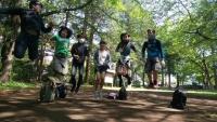 6人の参加者が森の中でカメラの方を向いて同時にジャンプをしている写真
