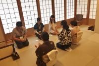 3名の女の子と3名が指導の女性が向かい合って座り茶道の作法を教わっている写真