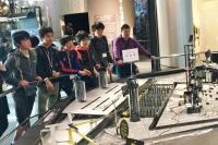 手すり越しに日本科学未来館にある模型を眺めている参加者たちの写真