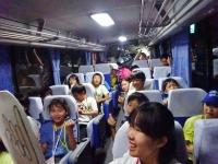 子供達が笑顔で話をしているバスの中の写真