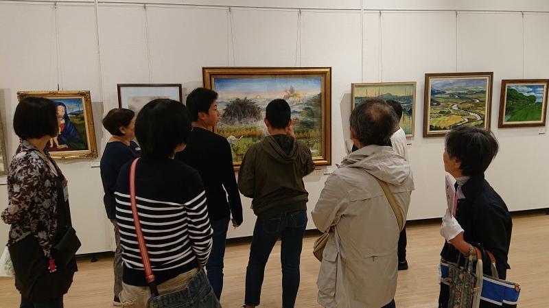 美術館内の絵画の作品の前で参加者が集まって観ている写真