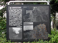 グレー色のボードに写真や地図、説明文が記された地名表示板の写真
