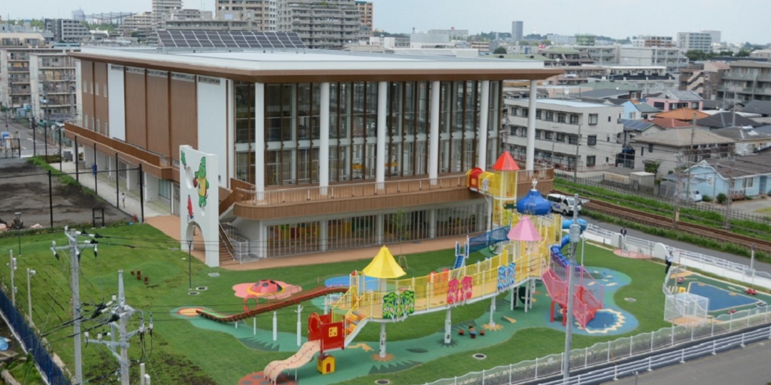 滑り台などの遊具の隣に大和市市民交流拠点ポラリスが建っている画像