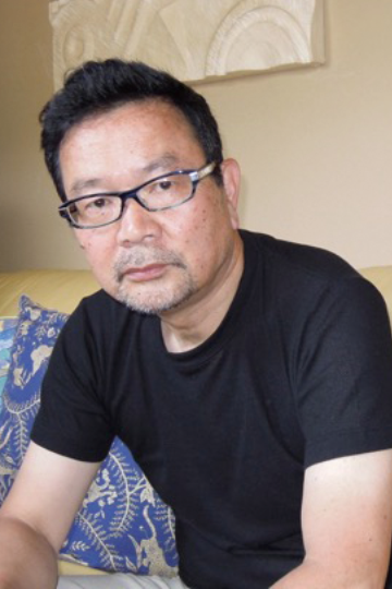 メガネをかけて黒色のシャツを着た青山 文平さんの写真