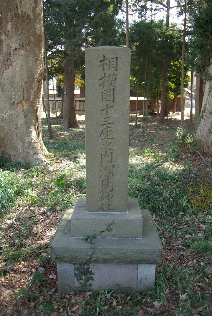 周囲を木々に囲まれ、正面に「相模国十三座之内深見神社」と刻まれた石碑の写真