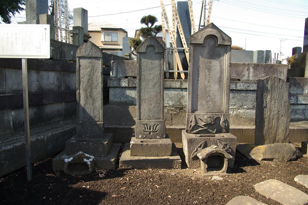 横に三つ並んだいろいろな形の墓石を正面から写している写真