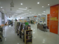 本棚が中央に写っている白い床と天井の渋谷図書館内の写真