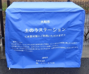 土のうステーションと書かれた青い袋が被せてある土のう袋の写真
