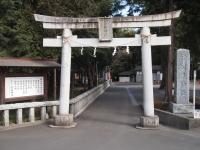 石の鳥居とその横に立つ看板と石碑の写真