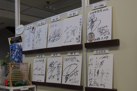 壁に9枚の芸能人のサイン色紙が飾られている様子が写っている写真