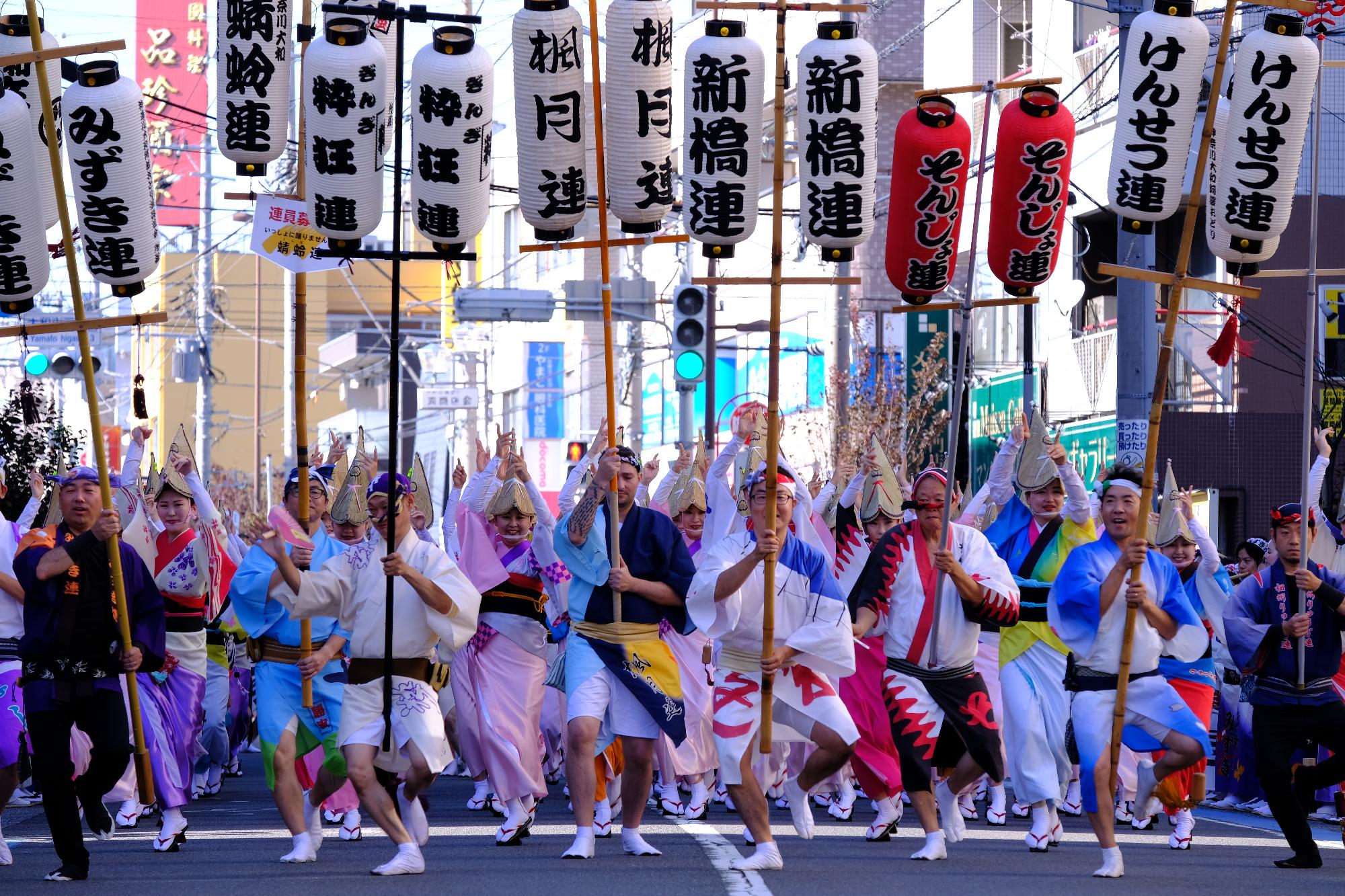 様々な連が提灯を掲げ楽しく踊る写真