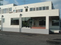 白い外壁で大きな四角い建物の大和市立中部学校給食共同調理場の外観写真