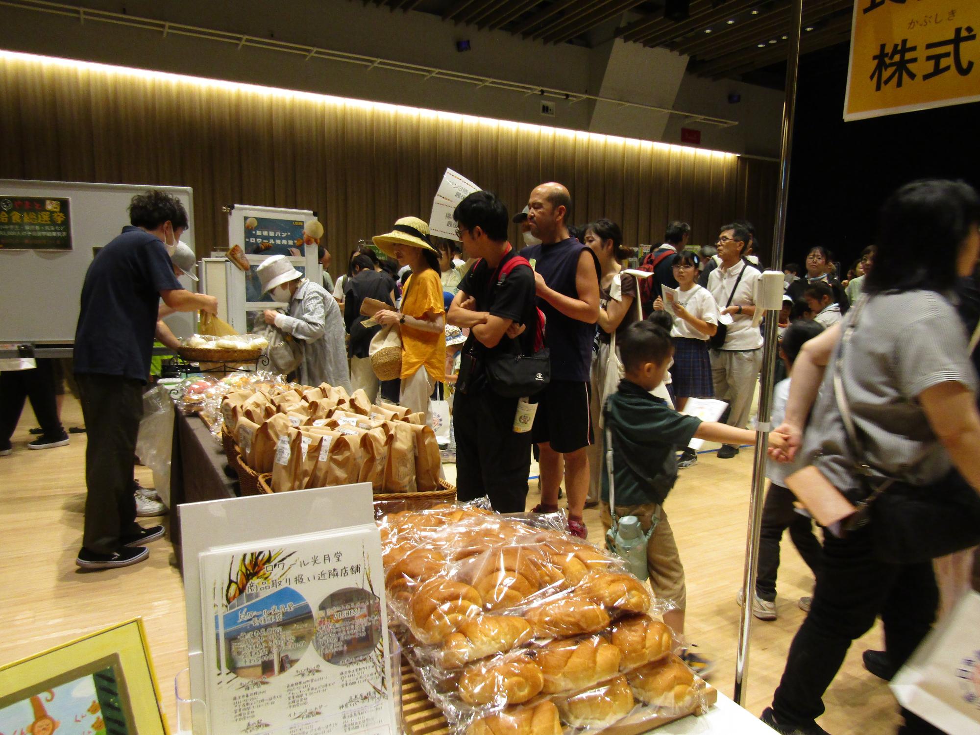 パン業者の給食パン販売ブースにたくさんの人が並んでいる様子