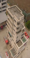 クリーム色のコンクリート建物の防災訓練センターを上空から見た写真