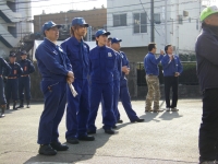 屋外で青い制服を着た隊員たちが横一列に並んでいる写真