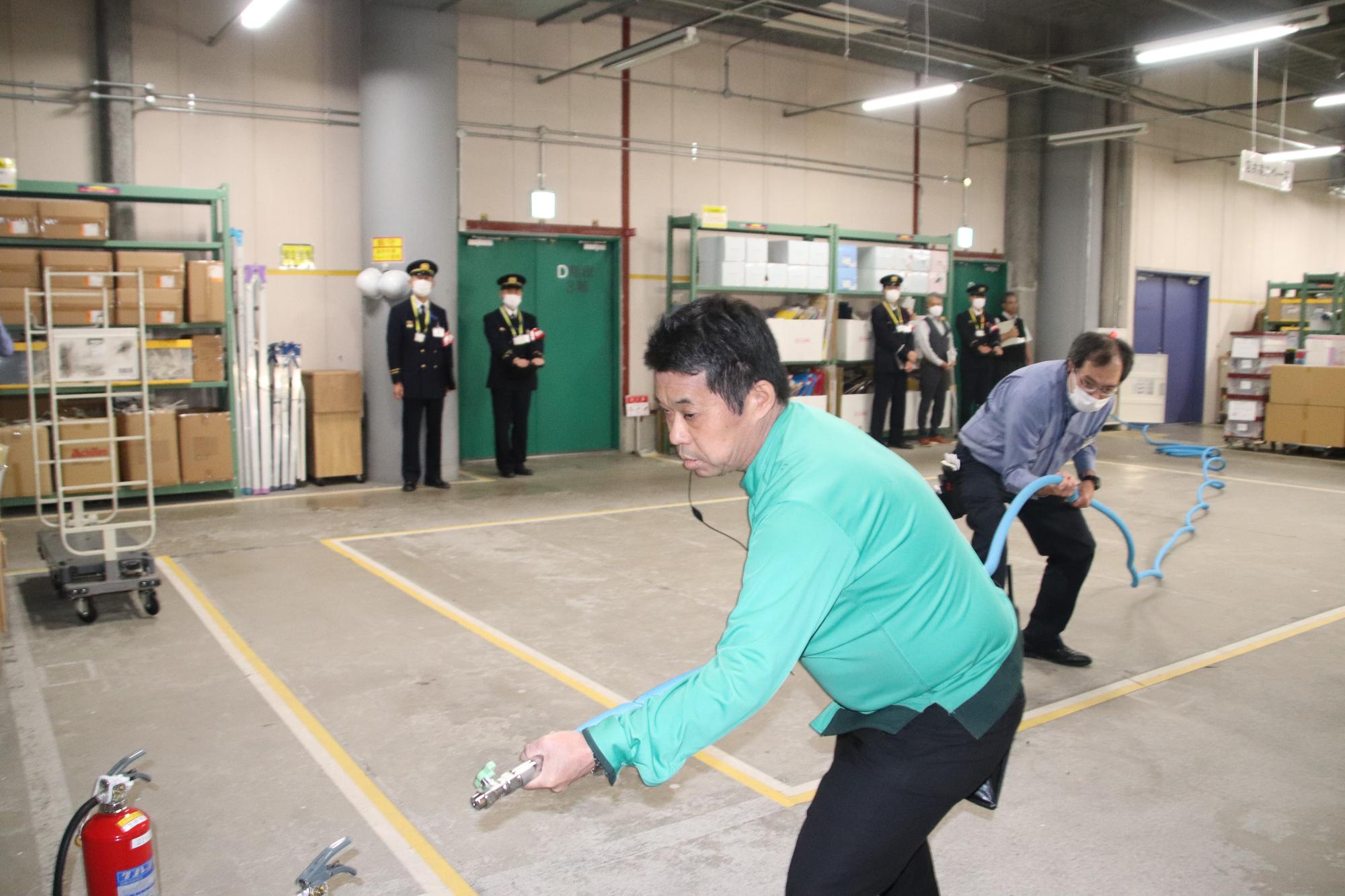 消防の制服を着用した男性が自動火災報知設備を確認している写真