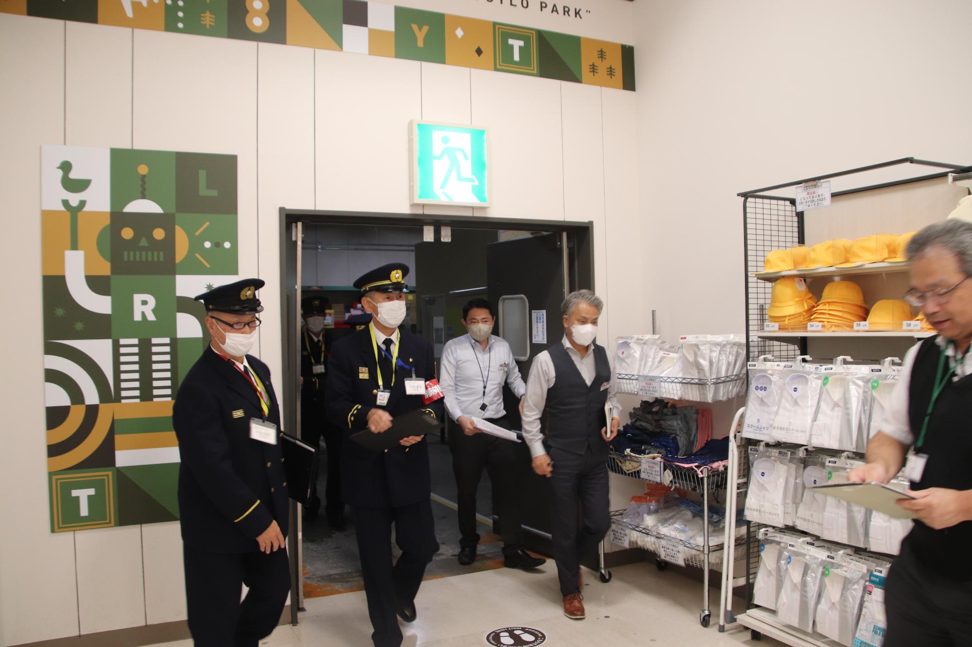 消防の制服を着用した男性が屋内消火栓のポンプについて確認している写真