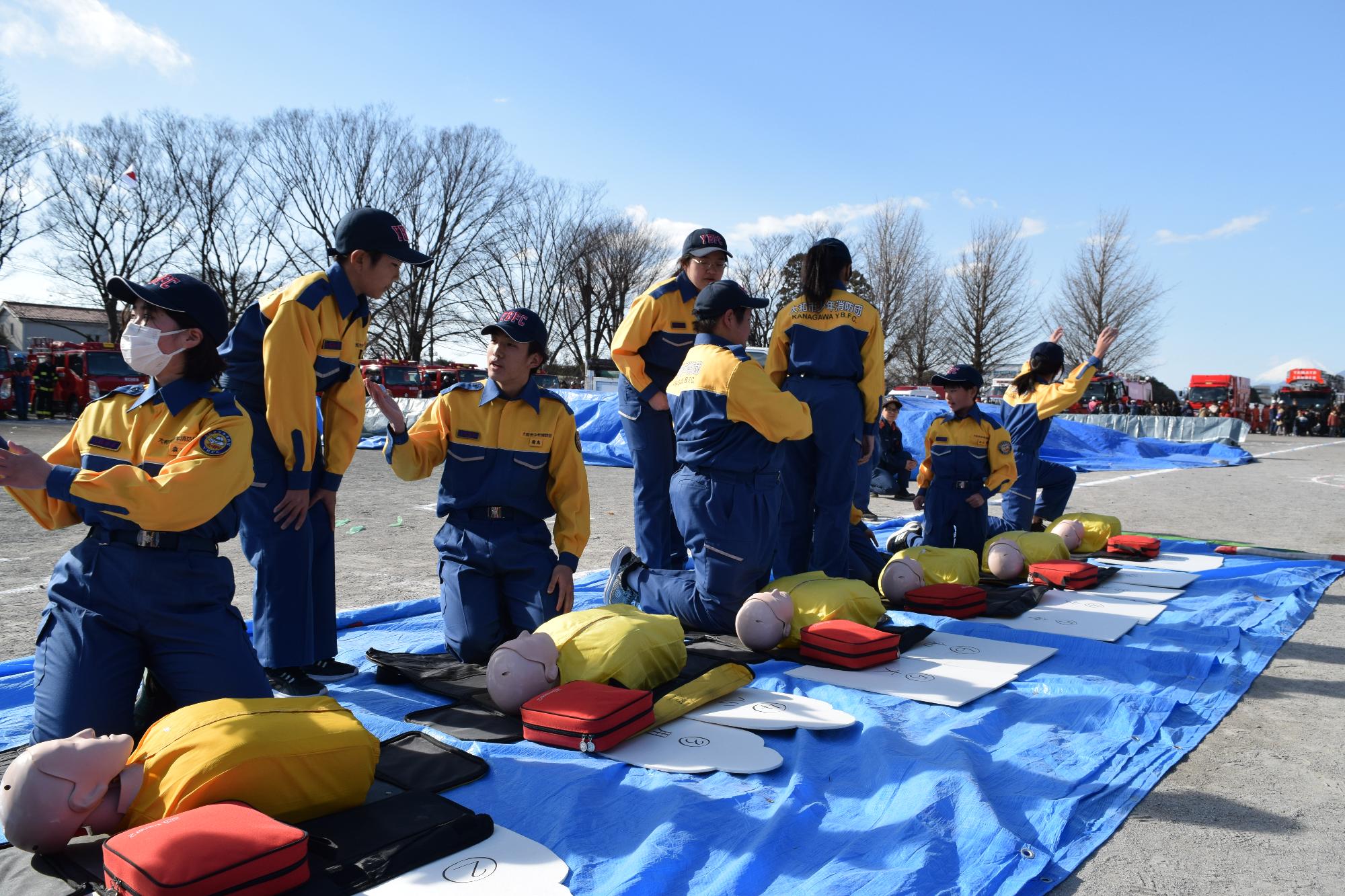 三角巾で応急手当の訓練をする少年消防団員