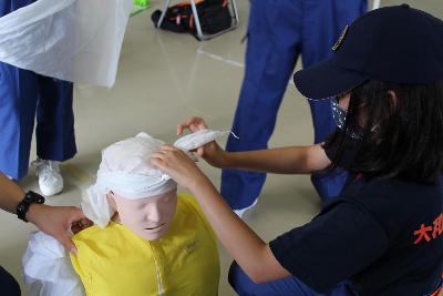 三角巾で頭を保護する練習をしている団員