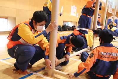 紙製の筒を組み立てて間仕切りを作る小中学生団員