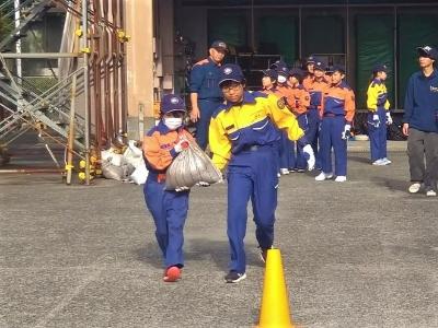 土のう袋を運ぶ少年消防団員たち