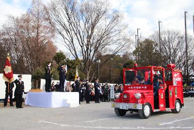 出初式でミニ消防車に乗っている少年消防団員