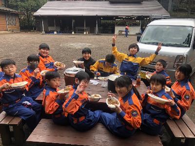 笑顔でカレーライスを食べる少年消防団員たち